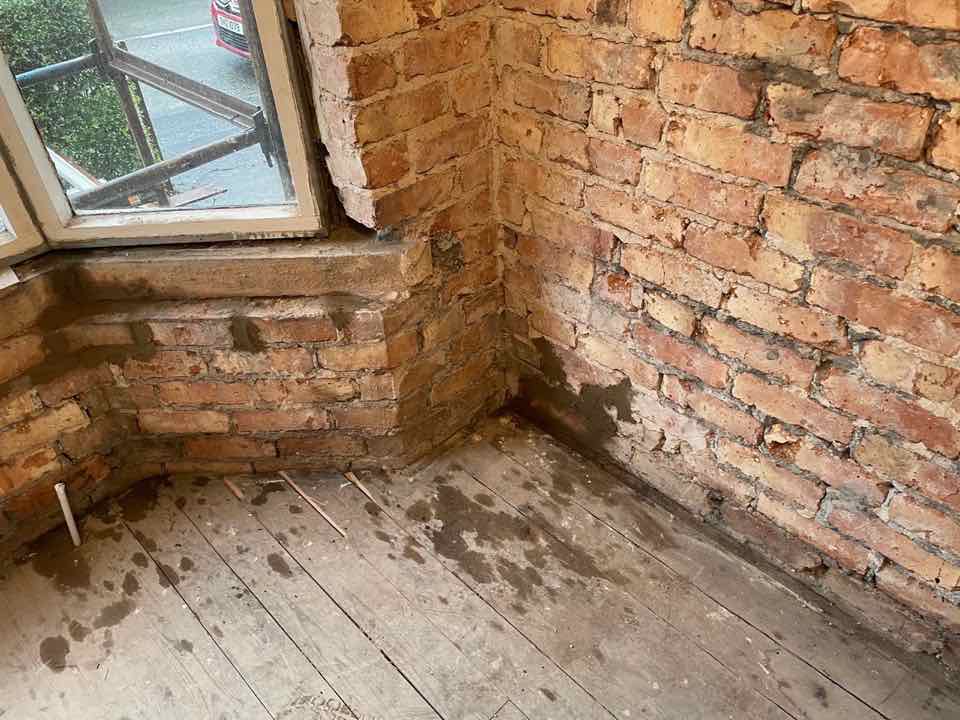 Fuktig tegel- och betongvägg före behandling